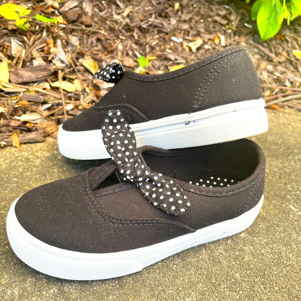 Girls black slip on canvas shoe with polka dot bow